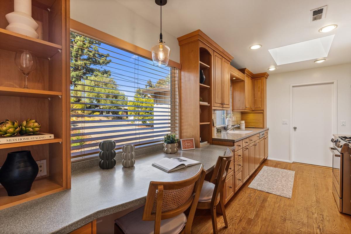 Eat-in kitchen counter by the window, with custom wood cabinetry