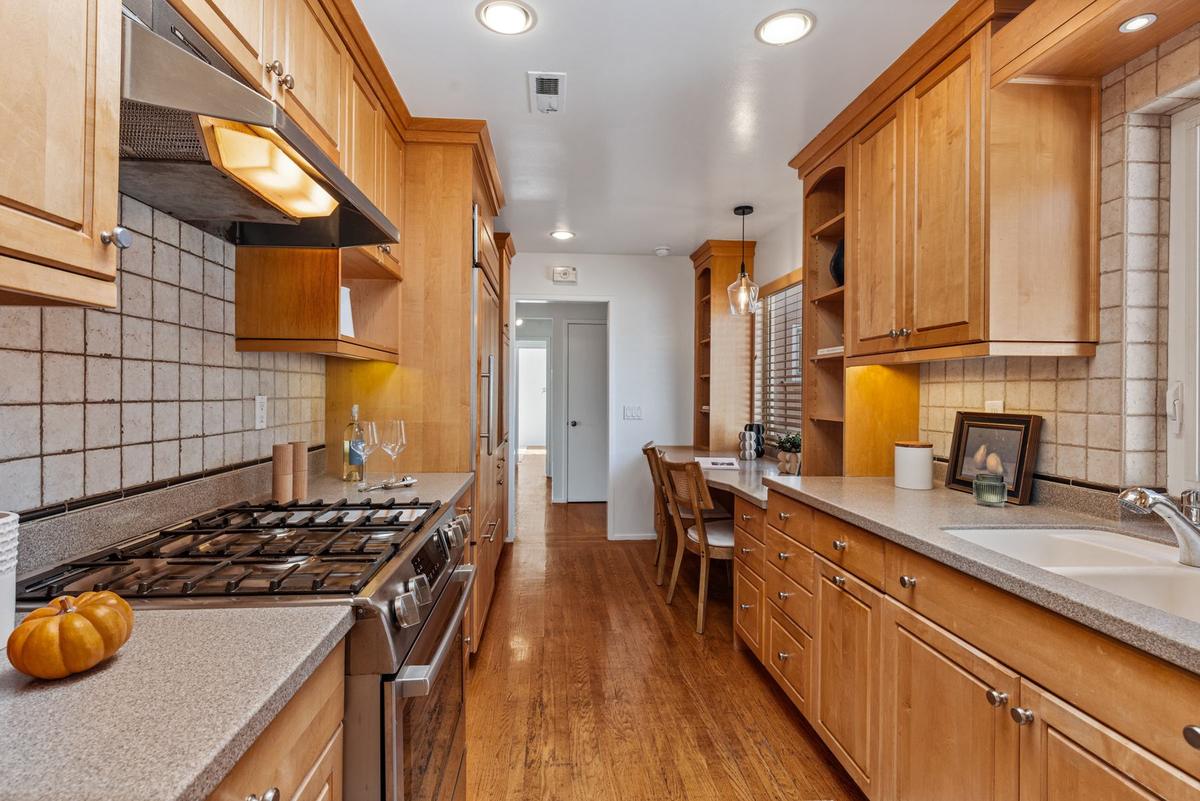Eat-in kitchen with custom cabinetry and a gas range