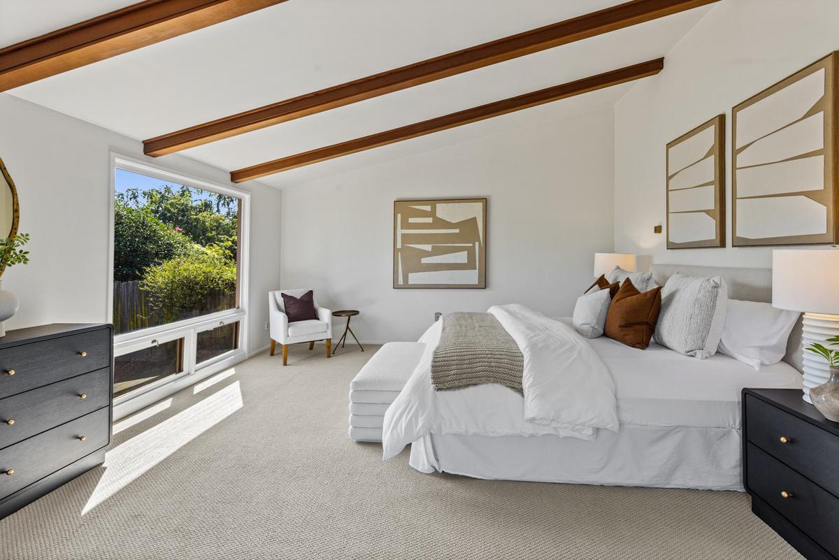 Primary suite with a beamed ceiling and a picture window