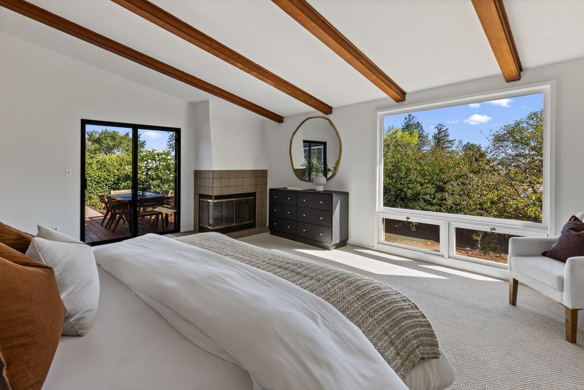 Primary suite with a corner fireplace and a sliding door to the deck